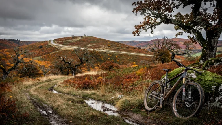 Paysage des Côtes de Meuse avec sentiers accidentés et VTT abandonné après une sortie doublée sans carte